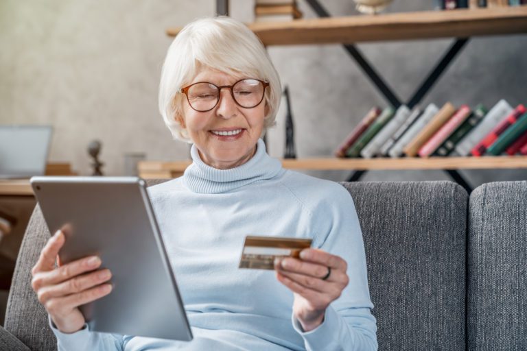 Senior woman using tablet computer and credit card
